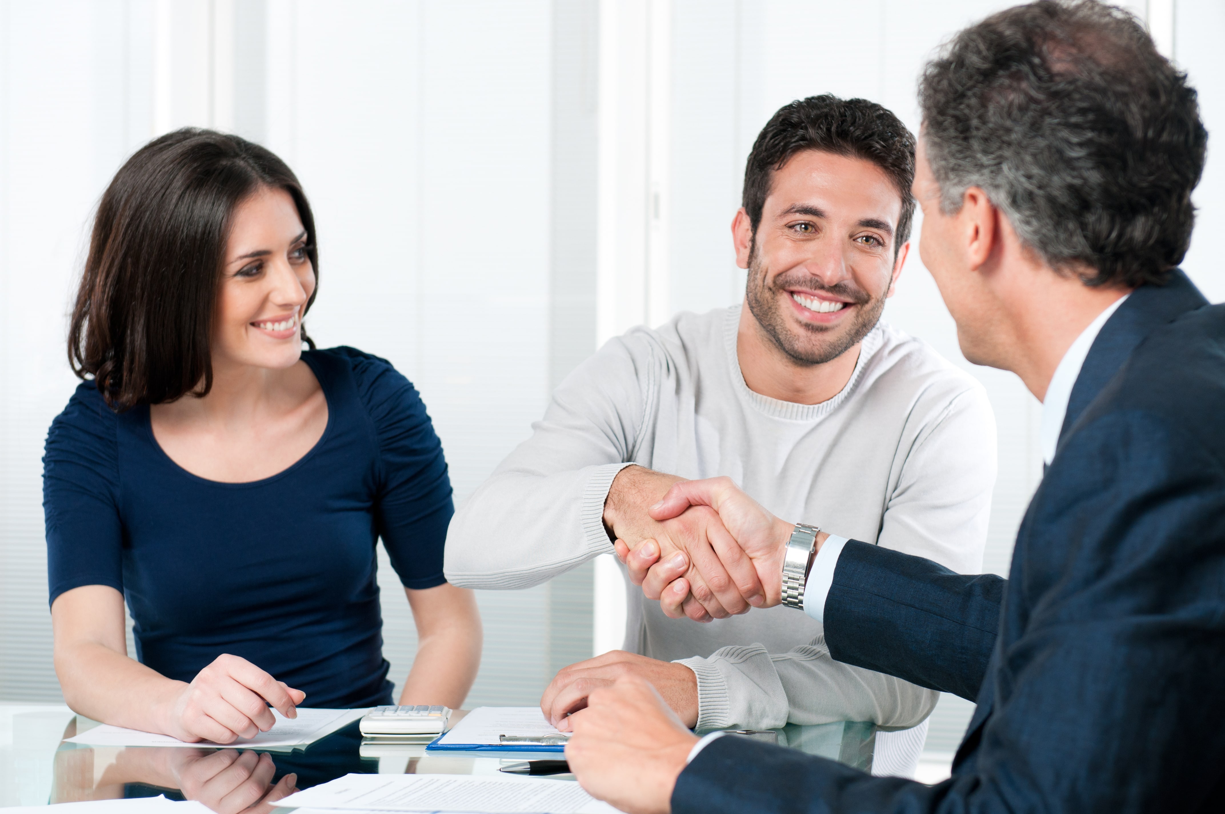 couple shaking hands with lawyer over documents - Post Nuptial Texas